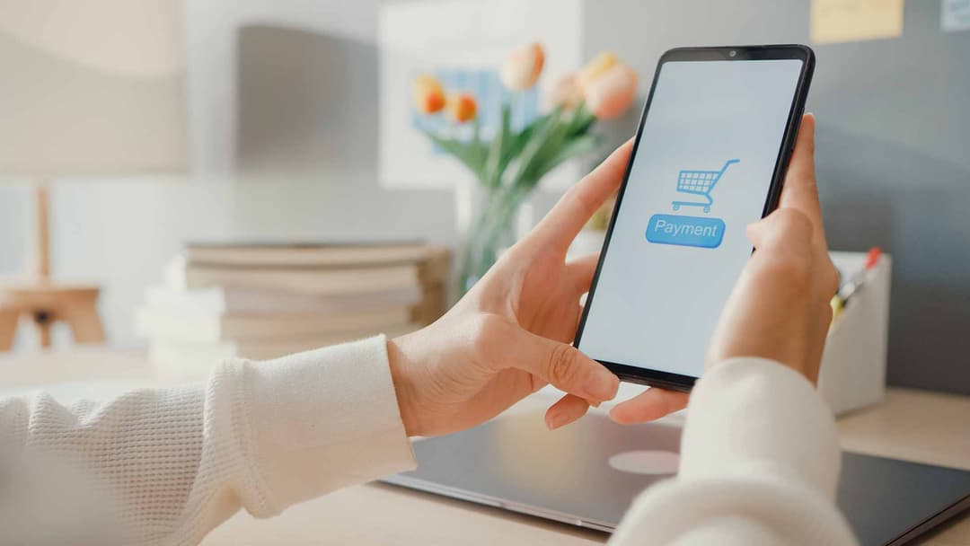 Smartphone mit Warenkorb-Symbol und Payment-Button: mobiler Bezahlvorgang in einem Onlineshop